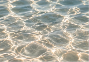 golden-sunlight-shimmering-across-clear-rippling-water-reflecting-Lunamar-Beautys-Mediterranean-resort-spa-aesthetic